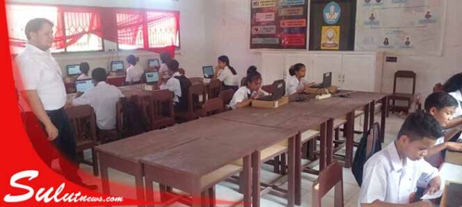 
 Foto - Suasana ANBK di SMP Negeri 11 Manado Diawasi Guru IT Alexander Sumendap ( kiri)