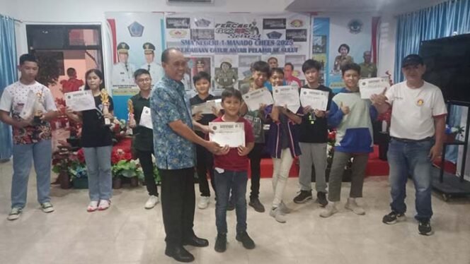 
Foto - Kepsek SMANSA Manado Jemmy Jermias S.Pd ( kiri) saat menyerahkan Piagan dan Hadia Kepada Salah Satu Pemenang