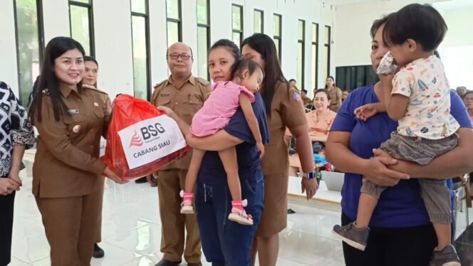 
Bupati Sitaro, Chyntia Ingrid Kalangit saat menyerahkan bantuan ke pada perwakilan anak yang hadir dalam Rakoor Tim Percepatan Penurunan Stunting