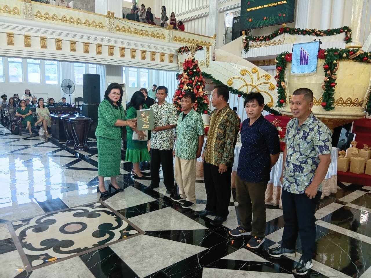 Foto - Kepsek SMK Negeri 1 Manado Telly Ticoalu Saat Berikan Bingkisan Natal Kepada Sekuriti, penjaga sekolah