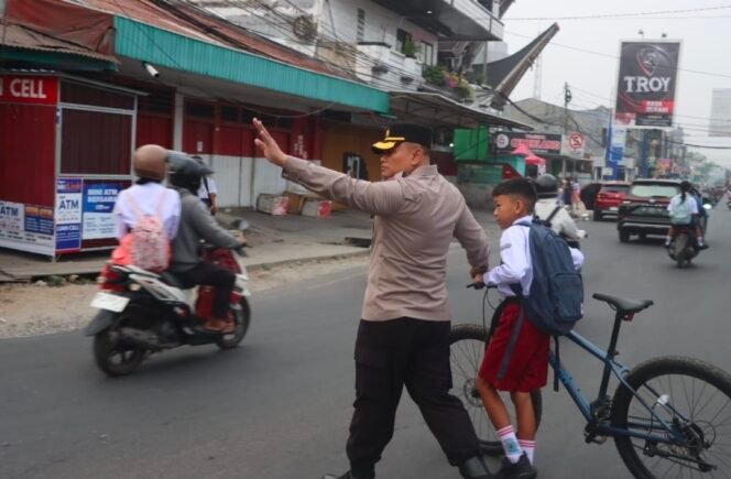 
 Turun Langsung Atur Lalu Lintas, Kapolres Torut Bantu Anak Sekolah Menyeberang